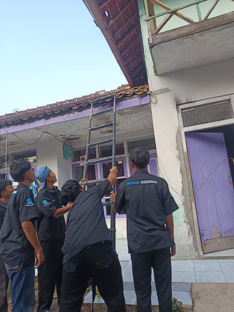 Teknisi menaikkan tangga teleskopik ke atap rumah pelanggan untuk pemasangan kabel